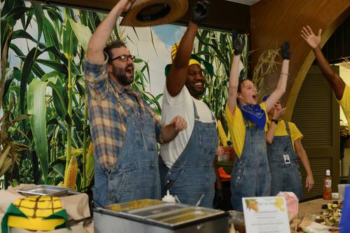 Corn-themed cooking team cheering after finishing their dish