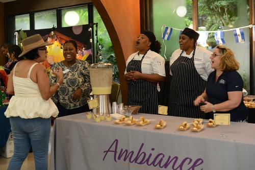 Chefs at the Ambiance booth laughing and singing with guests