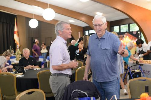 Veteran guest chatting warmly with a tablemate