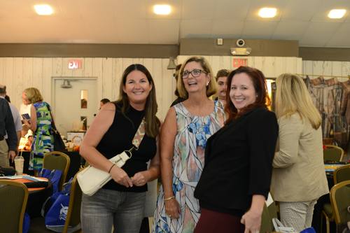 Three women laughing together at the reception