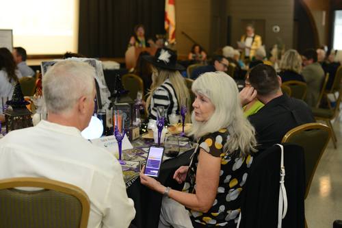 Guest checking her phone at a Halloween-themed table