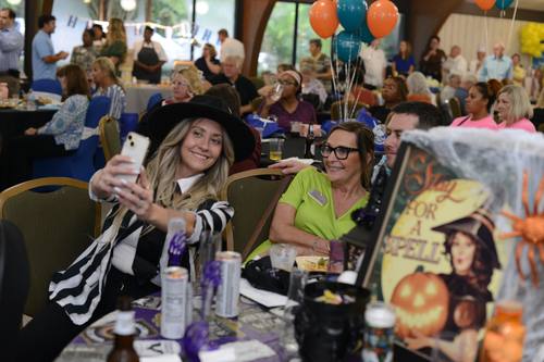 Friends taking a smiling selfie at a costume-themed table
