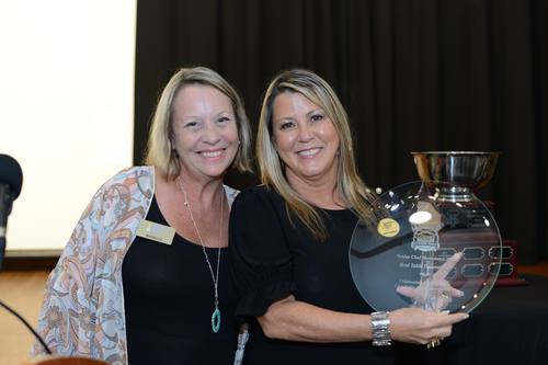 Two women proudly holding the "Best Table Decorations" award