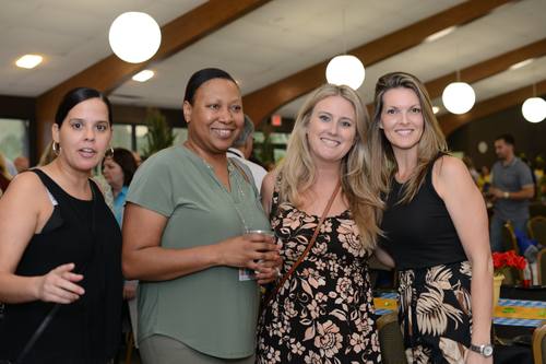 Four women posing together, all smiling for the camera