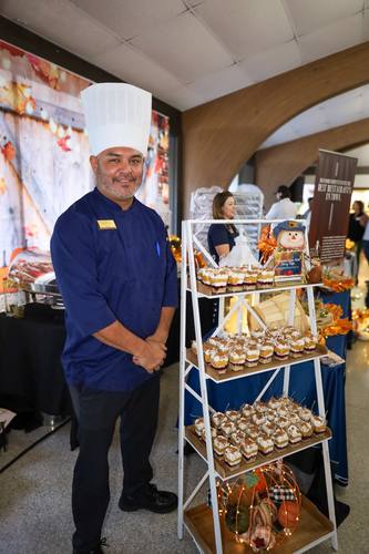 Chef Juan poses beside a towering pumpkin trifle display