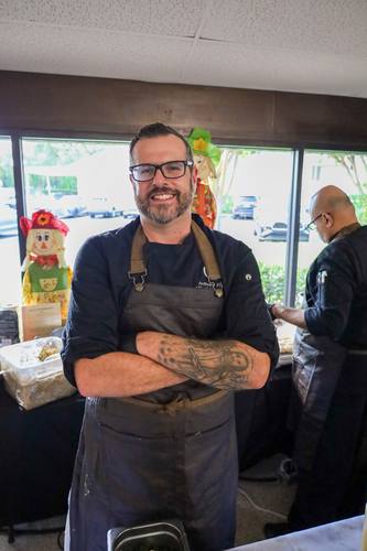Chef Anthony smiles with arms crossed in the dining hall