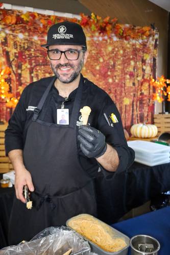 Chef grins while holding a freshly scooped ice cream cone