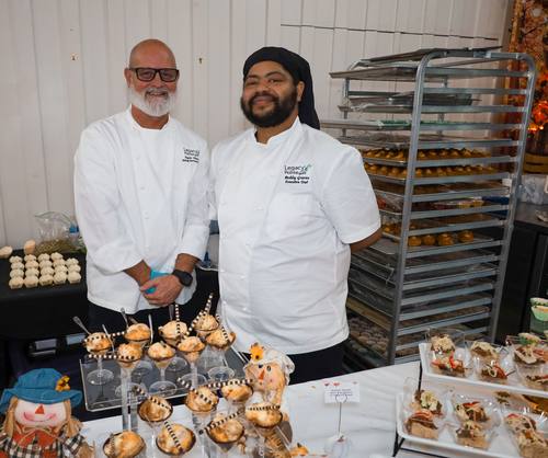 Two Legacy Pointe chefs pose together beside their dessert spread