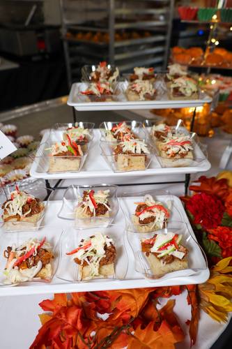 Tiered display of pulled pork sliders topped with slaw