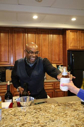 Bartender laughs while pouring a drink for a guest
