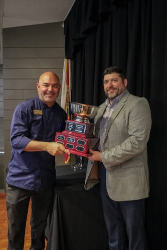 Chef Juan holds the Champion trophy beside the $32,619 total