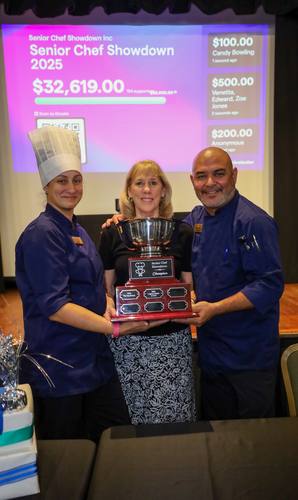 Chef Juan and teammates hold the Champion trophy on stage